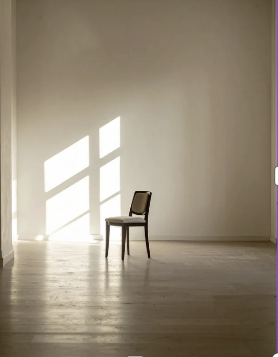 Klar bleiben, wenn das Leben sich verändert. Ein einzelner Stuhl steht in einem leeren Raum mit Lichtstrahlen auf dem Boden.